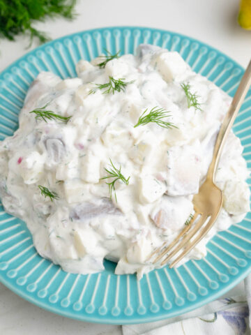 Herring in Cream Sauce on a blue plate.