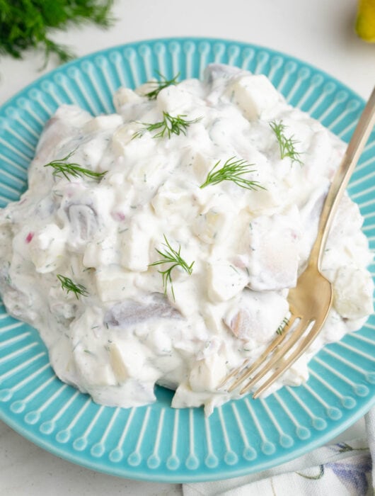 Herring in Cream Sauce on a blue plate.