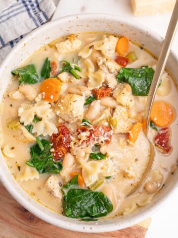 Tuscan chicken soup in a white bowl.