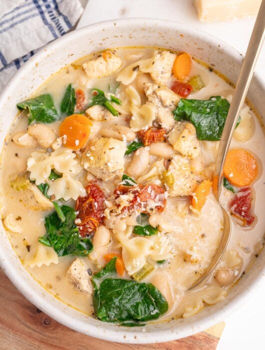 Tuscan chicken soup in a white bowl.