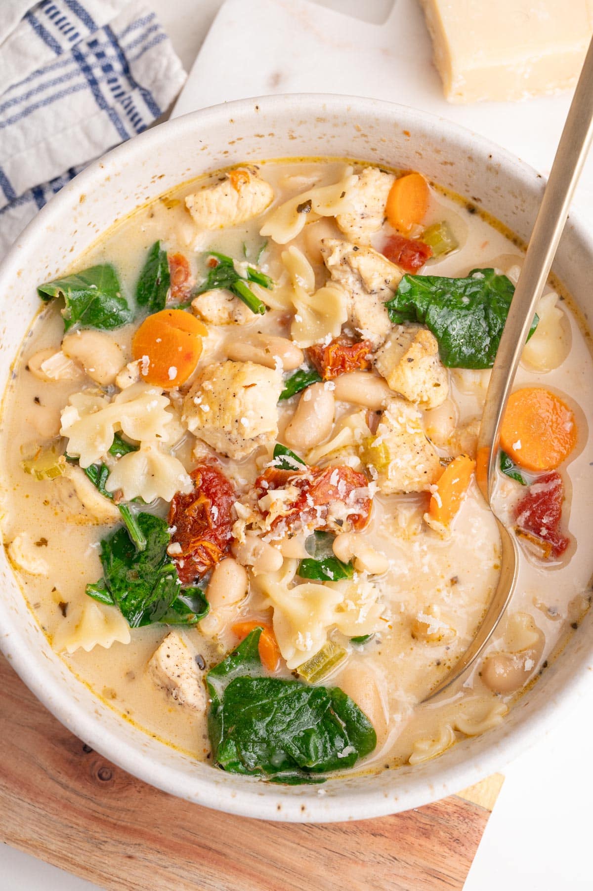 An overhead photo of Tuscan chicken soup in a white bowl.