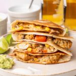 A stack of chicken quesadillas on a beige plate.