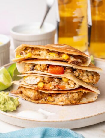 A stack of chicken quesadillas on a beige plate.