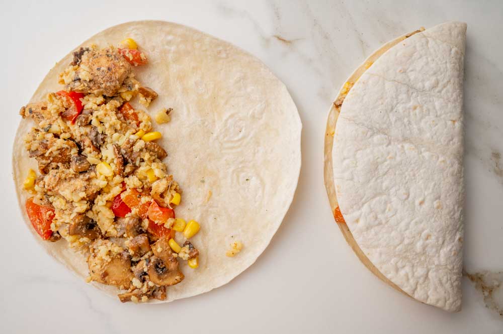 Chicken quesadillas ready to be cooked on a white countertop.