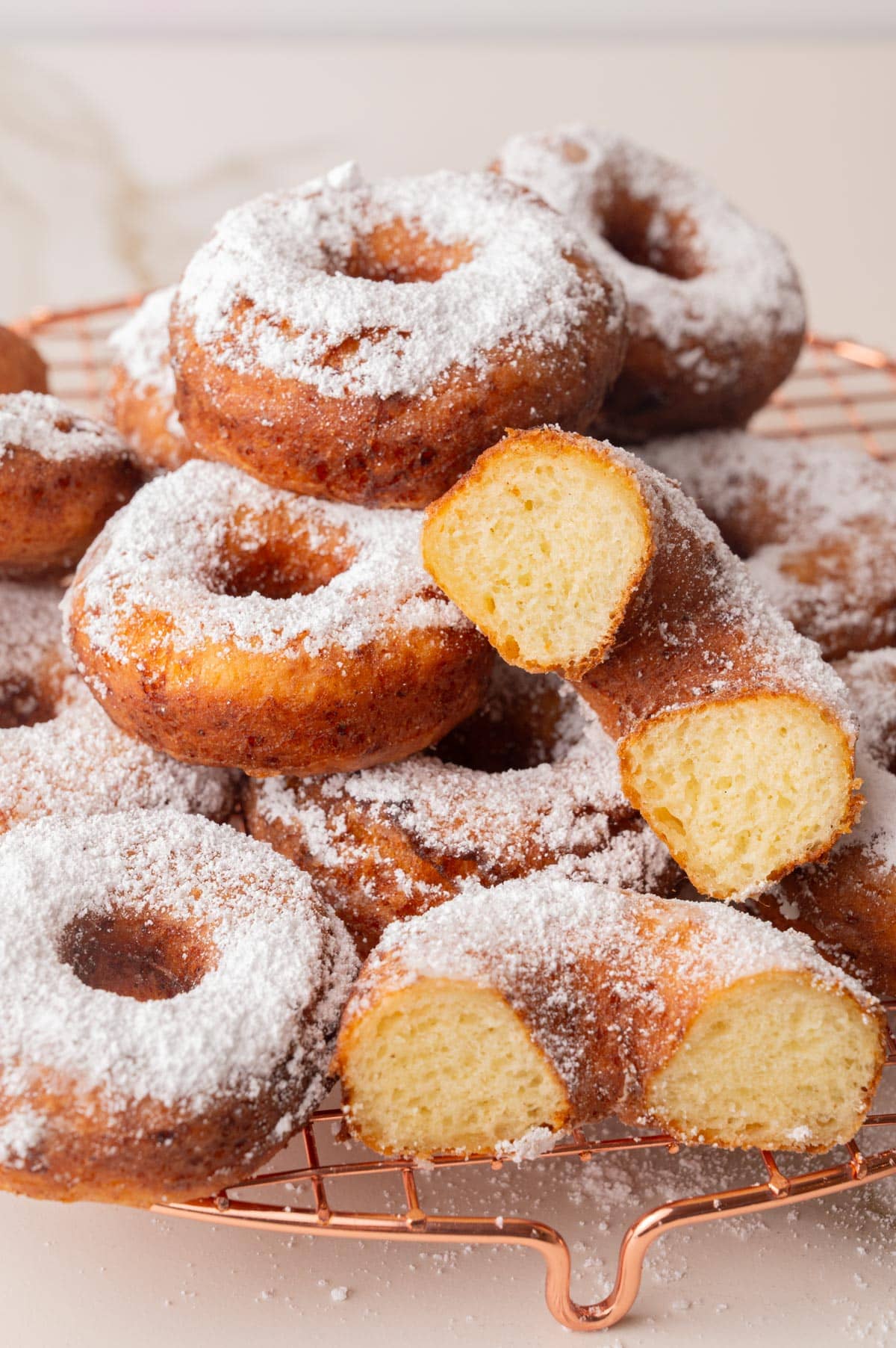 Oponki donuts on a gold cooling rack.