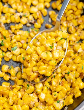 A close up photo of sauteed corn in a cast iron pan.