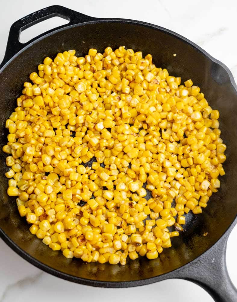 Pan-fried corn kernels in a cast iron pan.