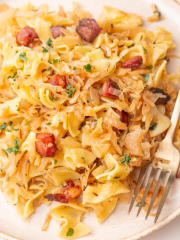 Austrian cabbage and noodles with Speck (Krautflecker) on a beige plate.