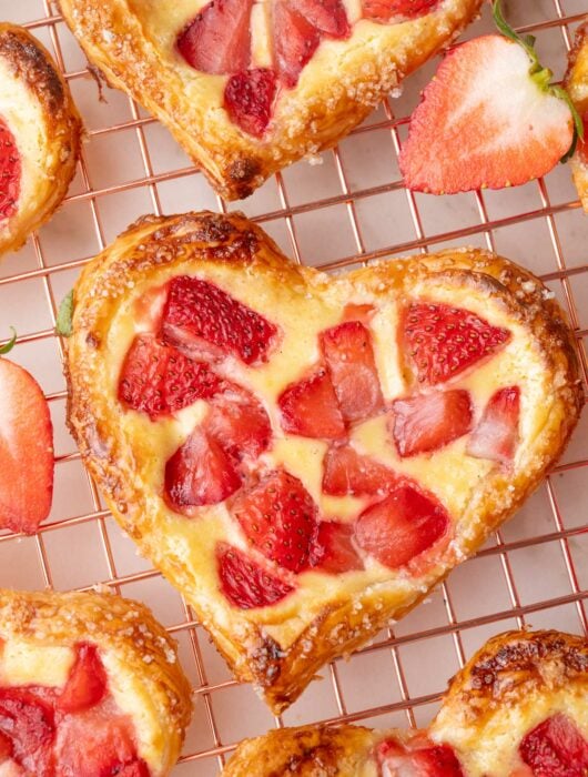 Valentine's strawberry puff pastry hearts on a cooling rack.