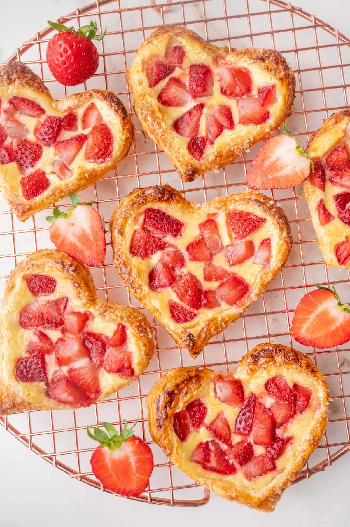 Valentine's Strawberry Puff Pastry Hearts on a gold cooling rack.