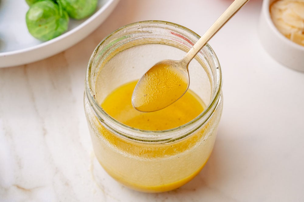 Salad dressing in a jar and a teaspoon.