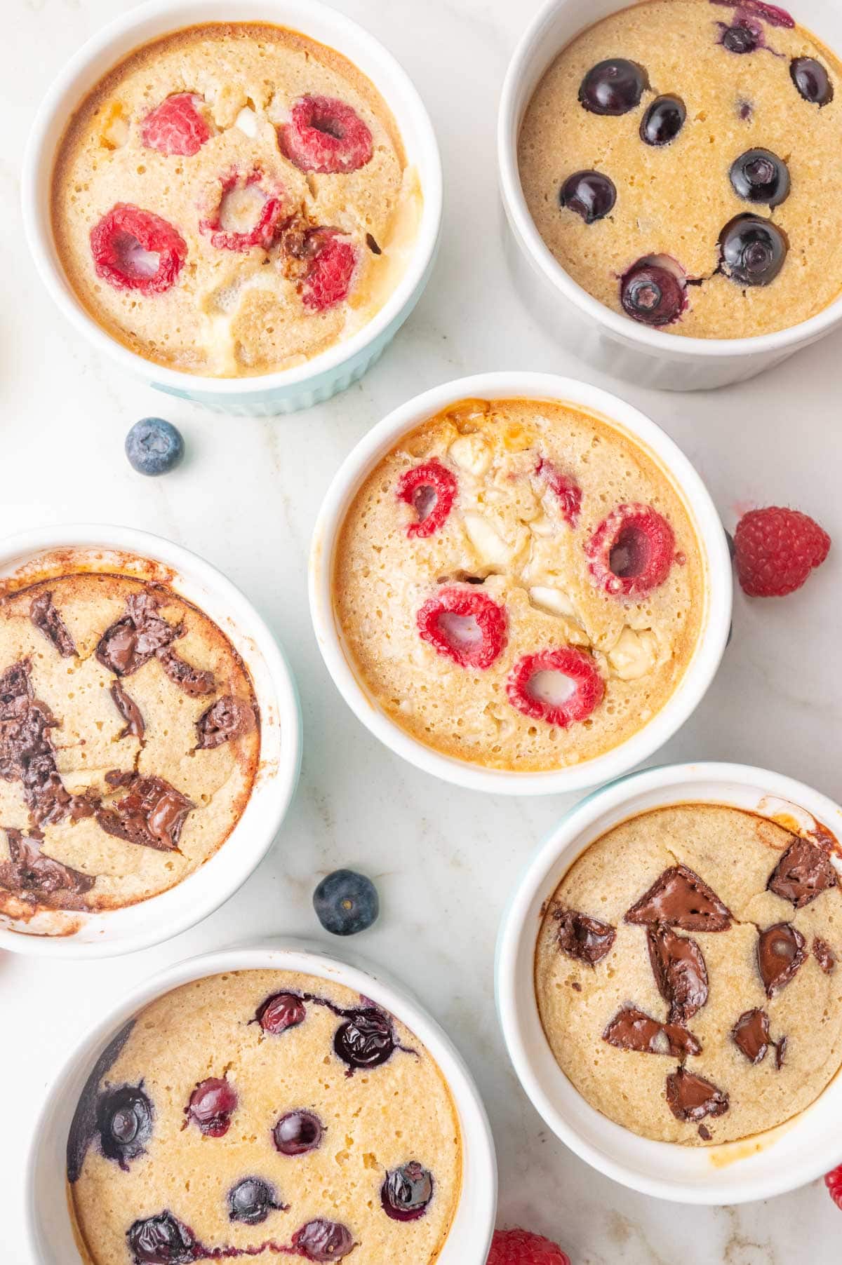 Small ramekins with baked oats in different flavors on a counter.