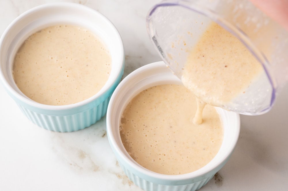 Baked oats batter is being poured into ramekins.