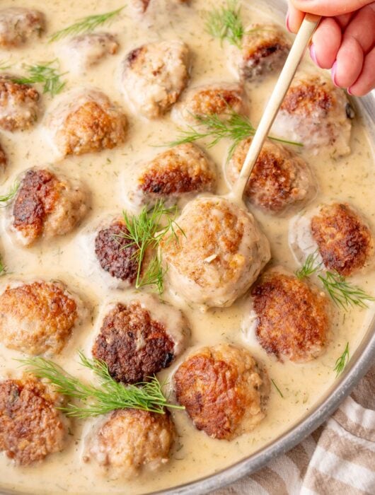 Polish meatballs in dill sauce in a frying pan.