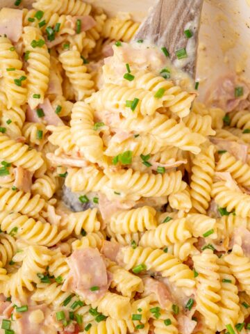 A close-up photo of German pasta dish Schinkennudeln in a white pot.