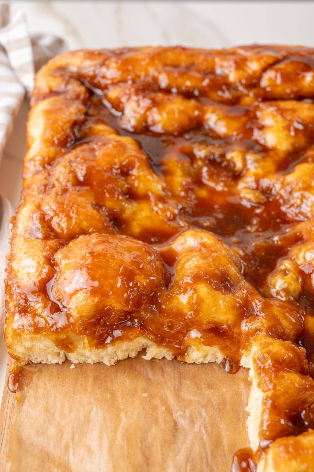 Brunsviger cake on a wooden board with one piece missing.