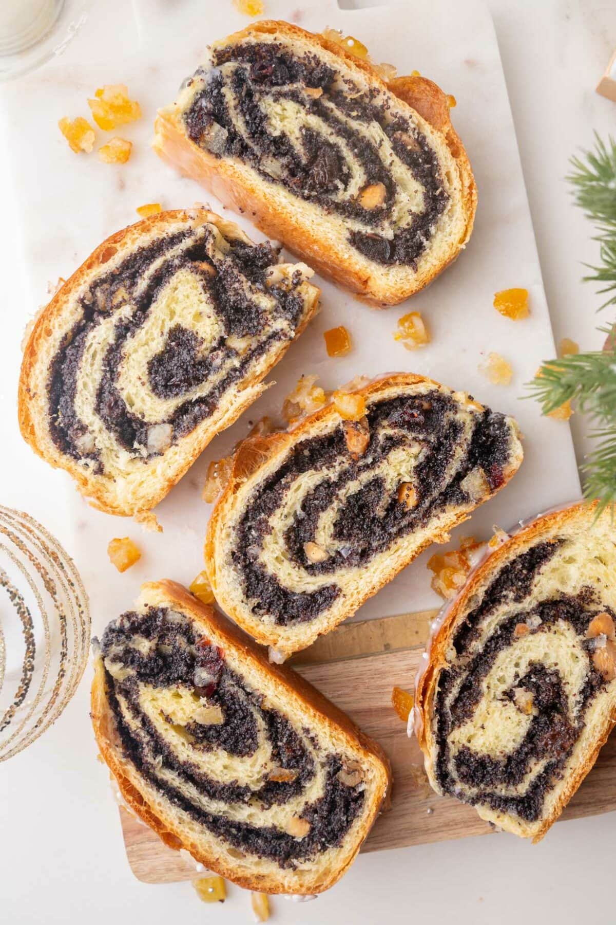 Slices of poppy seed roll on a marble board.