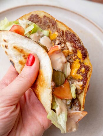 A Big Mac taco is being hold in a hand.